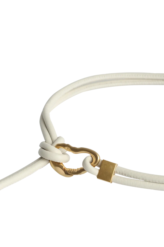 Cinto de couro na cor preto com fivela metálica dourada elegante com acabamento com costuras reforçadas, essencial para marcar a cintura com sutileza, aliando durabilidade e elegância no vestuário diário.