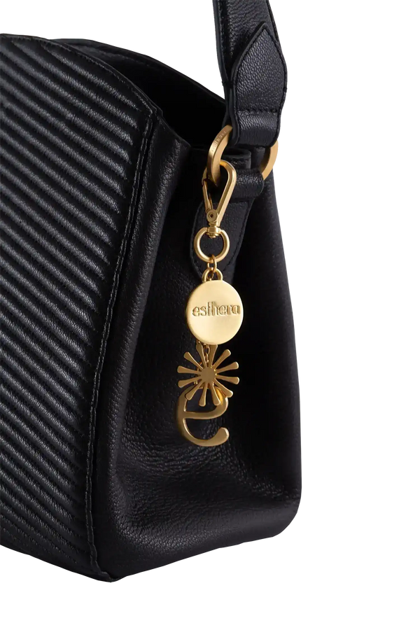 Bolsa preta com textura e detalhe dourado 'esthera', design brasileiro sofisticado e funcional