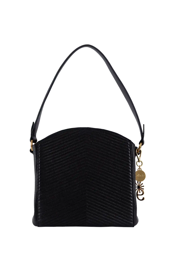 Bolsa preta com textura em V, alça longa e detalhe dourado, design brasileiro sofisticado e funcional.