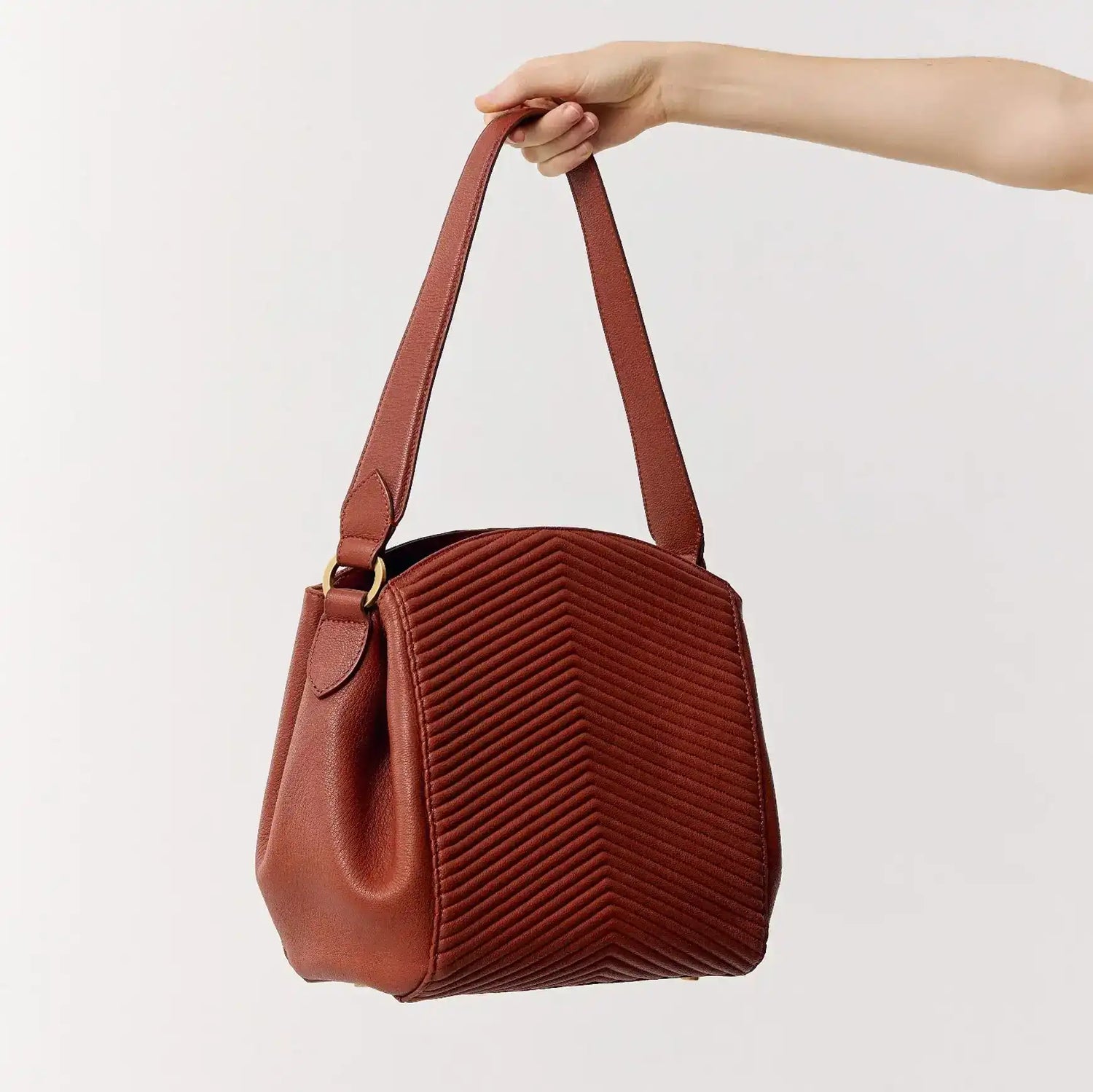 Bolsa marrom com textura em V, alça longa e design sofisticado para uso diário