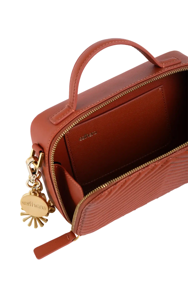 Bolsa em couro marrom com detalhes dourados e textura ondulada, ideal para acessórios elegantes.