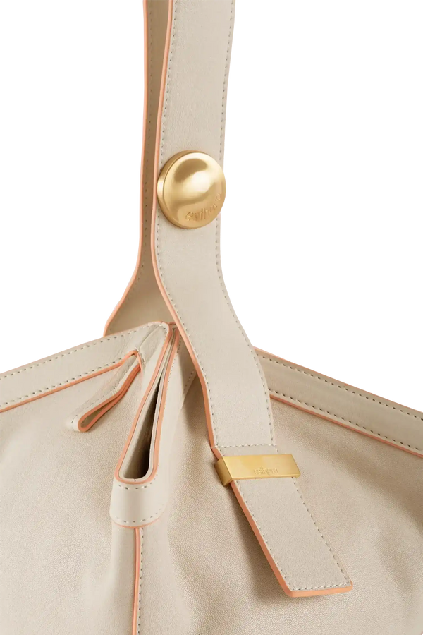 Bolsa de couro bege com detalhes em rosa e metais dourados, design sofisticado e costuras precisas