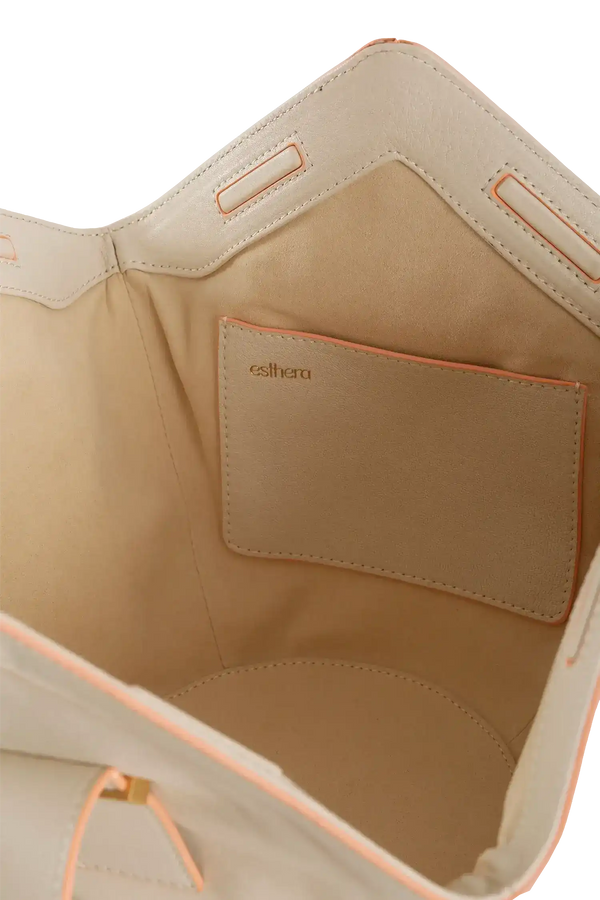 Interior de bolsa bege com detalhes em rosa e logo Esthera, design brasileiro e sofisticado
