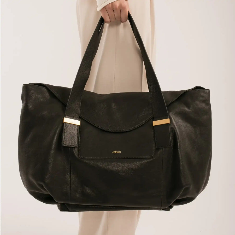 Bolsa preta de couro com alças largas e detalhes dourados, design sofisticado e funcional