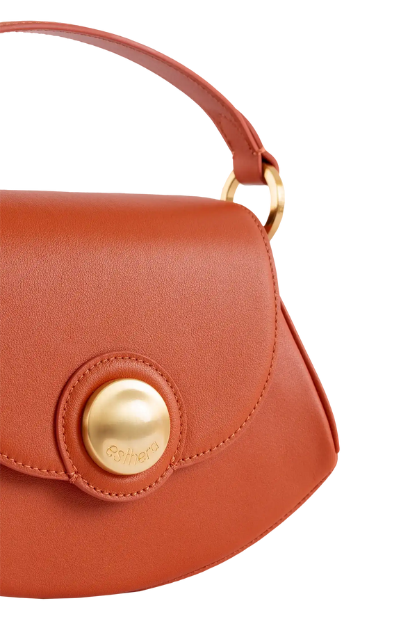 Bolsa em couro laranja com detalhe dourado e logo Esthera, design brasileiro sofisticado