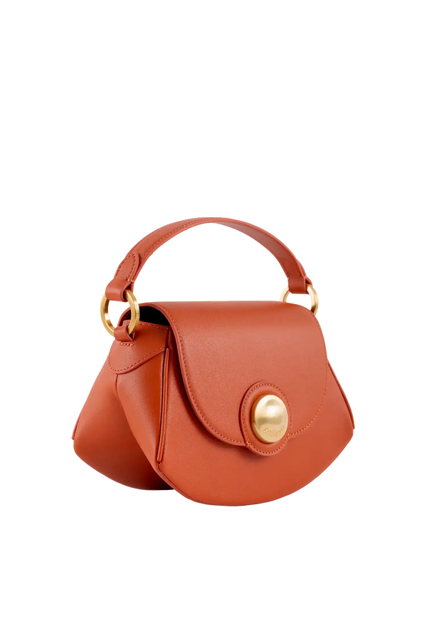 Bolsa de couro laranja com alça de mão e detalhe dourado, design brasileiro sofisticado e funcional