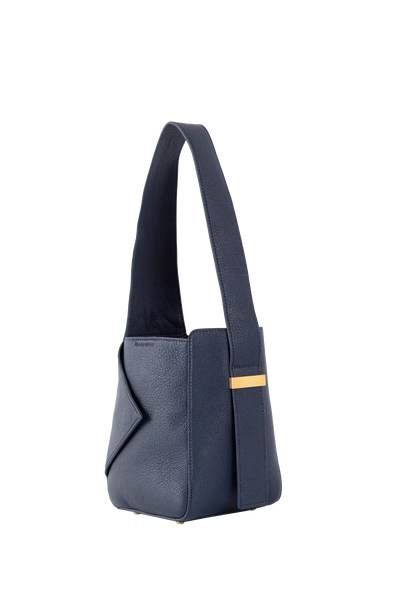 Bolsa azul marinho com alça longa e detalhe dourado, design brasileiro e sofisticado para uso diário.