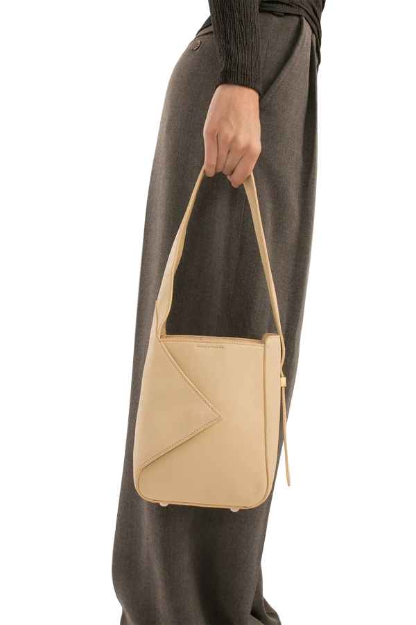 Bolsa bege com design moderno e alça longa, perfeita para uso diário e estilo sofisticado.