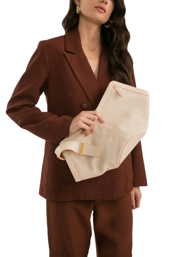 Bolsa clutch bege com detalhes rosa, usada por mulher em terno marrom, estilo sofisticado e funcional