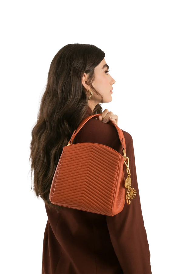 Bolsa marrom com costura em zigue-zague e detalhes dourados, ideal para looks sofisticados e funcionais.