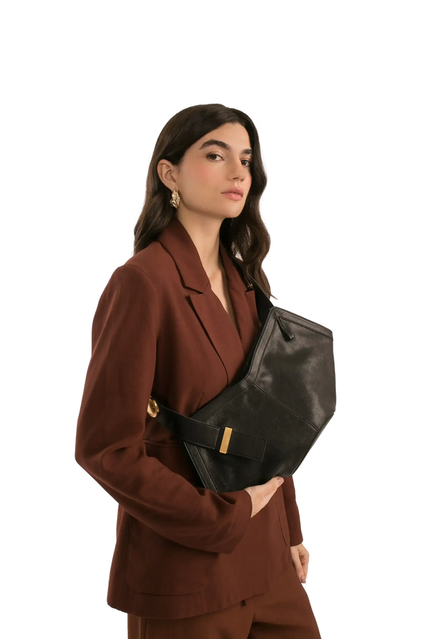 Bolsa preta elegante com detalhes dourados, combinando com blazer marrom