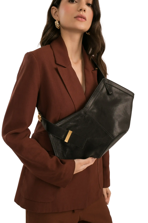 Bolsa preta elegante com detalhes dourados, combinando com blazer marrom