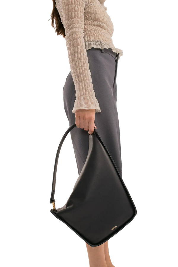 Bolsa preta de couro com alça longa, design moderno e sofisticado, perfeita para looks elegantes e funcionais.