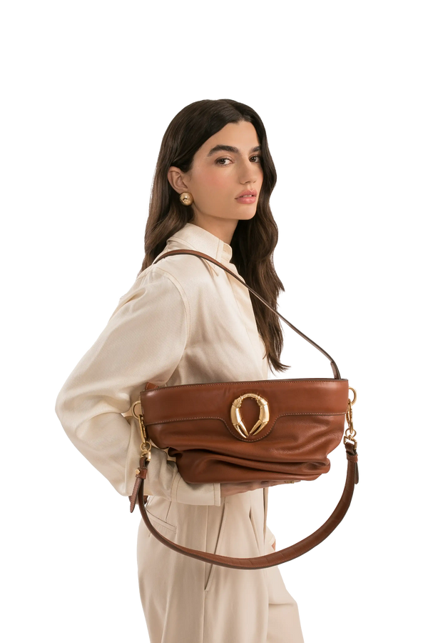 Bolsa de ombro em couro legítimo na cor marrom claro com fechamento por zíper e alça de ombro confortável, design sofisticado e funcional ideal para o dia a dia.