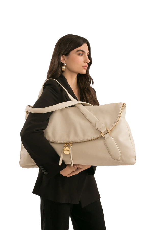Bolsa grande bege com alça longa e detalhes dourados, ideal para uso diário e looks sofisticados.