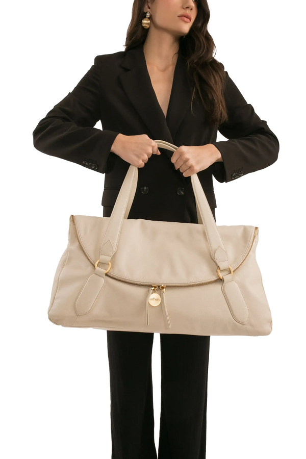 Bolsa de couro bege com alça longa e detalhes dourados, perfeita para look sofisticado e funcional.