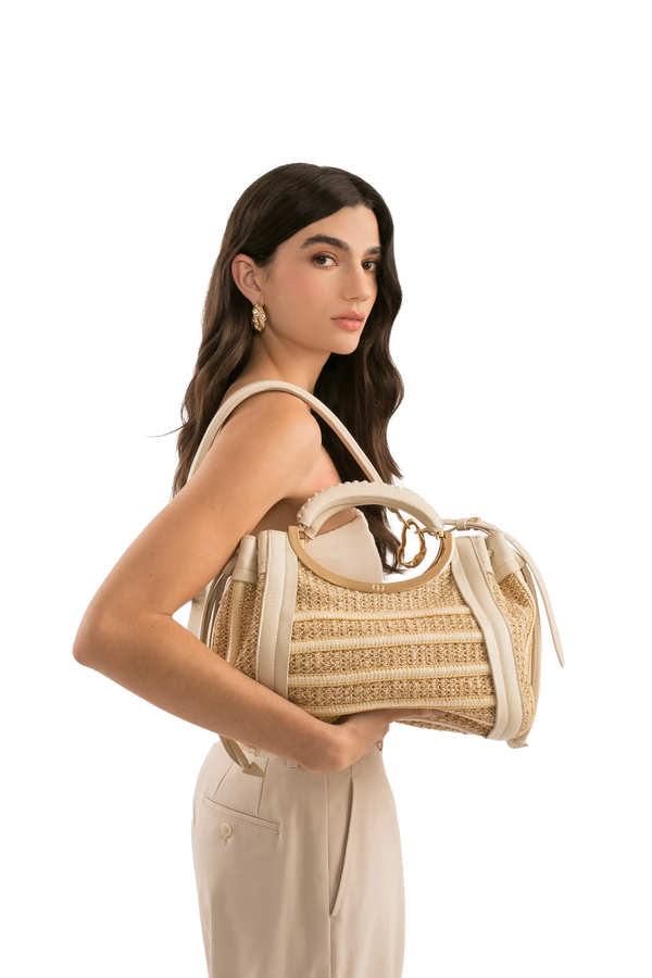 Bolsa de palha com alça circular dourada e detalhes em couro bege, ideal para looks sofisticados e funcionais.