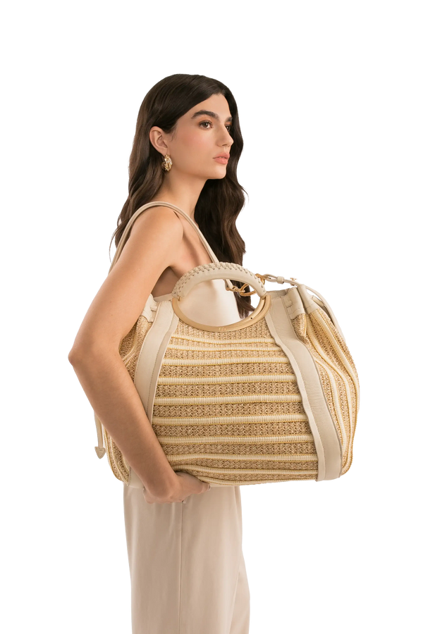 Bolsa de palha com alça circular e detalhes em couro bege, ideal para looks sofisticados e funcionais.