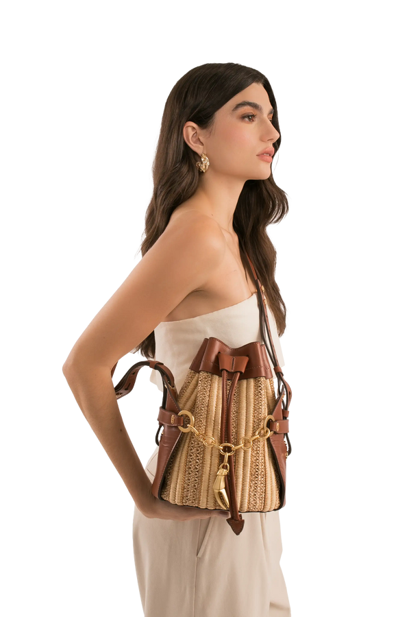 Bolsa de palha com detalhes em couro marrom e corrente dourada, ideal para looks sofisticados e funcionais.