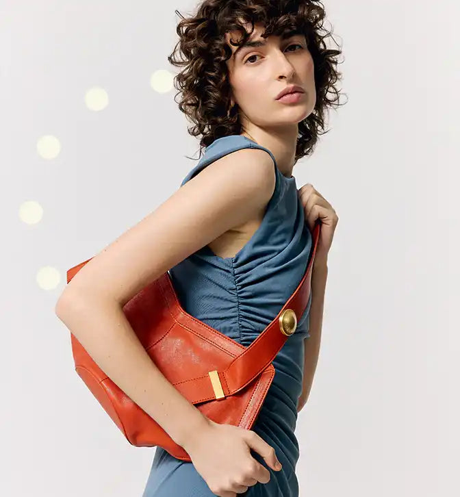 Bolsa vermelha com detalhes dourados, estilo moderno e sofisticado, ideal para looks casuais e elegantes.