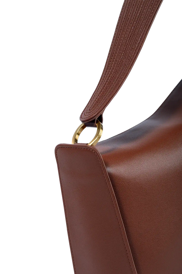 Bolsa marrom em couro com alça texturizada e detalhe metálico dourado, design sofisticado e funcional.