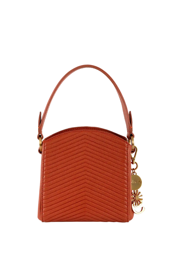 Bolsa laranja com costura em V, alça curta e detalhes dourados, design brasileiro sofisticado