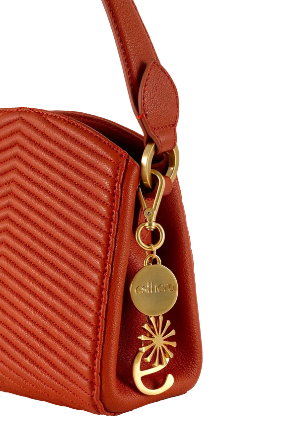 Bolsa vermelha com costura em zigue-zague e detalhe dourado da marca esthera