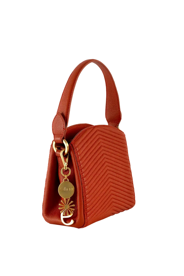 Bolsa vermelha com costura em zig-zag e detalhes dourados, design brasileiro sofisticado