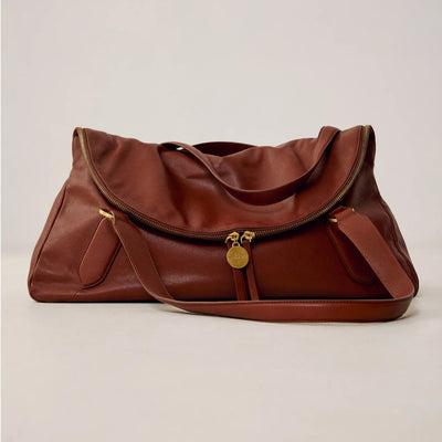 Bolsa marrom de couro com alça longa e zíper dourado, design sofisticado e funcional para uso diário.