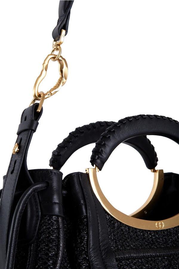 Bolsa preta com alça trançada e detalhes dourados, design sofisticado e funcional