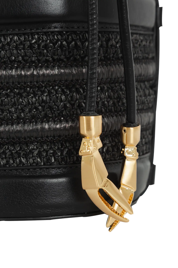 Bolsa preta com textura trançada e detalhe dourado em forma de garras, design sofisticado e funcional