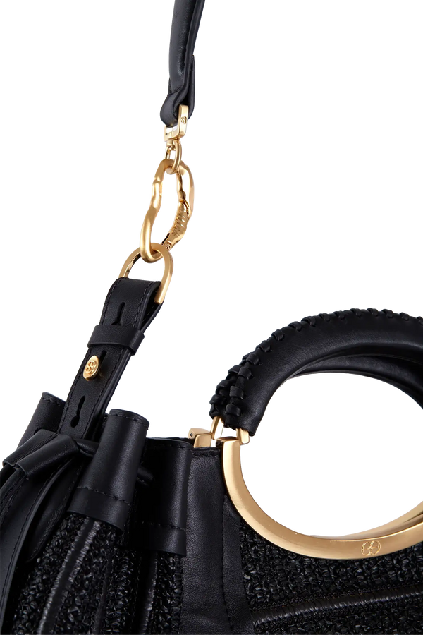 Bolsa preta com alça circular dourada e detalhes em couro, design sofisticado e funcional