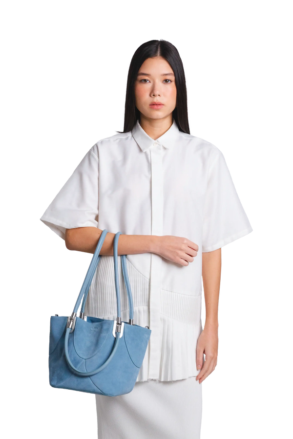 Bolsa de mão em camurça na cor com tom elegante com fechamento seguro e alça ajustável confortável, design sofisticado e funcional ideal para o dia a dia.