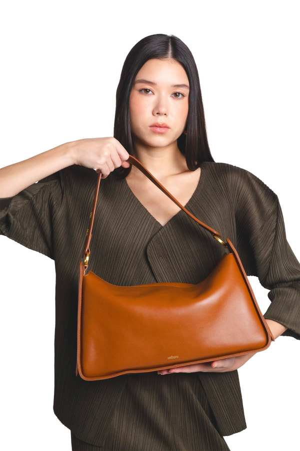 Bolsa de ombro em couro legítimo na cor marrom claro com fechamento por zíper e alça de ombro confortável, design sofisticado e funcional ideal para o dia a dia.