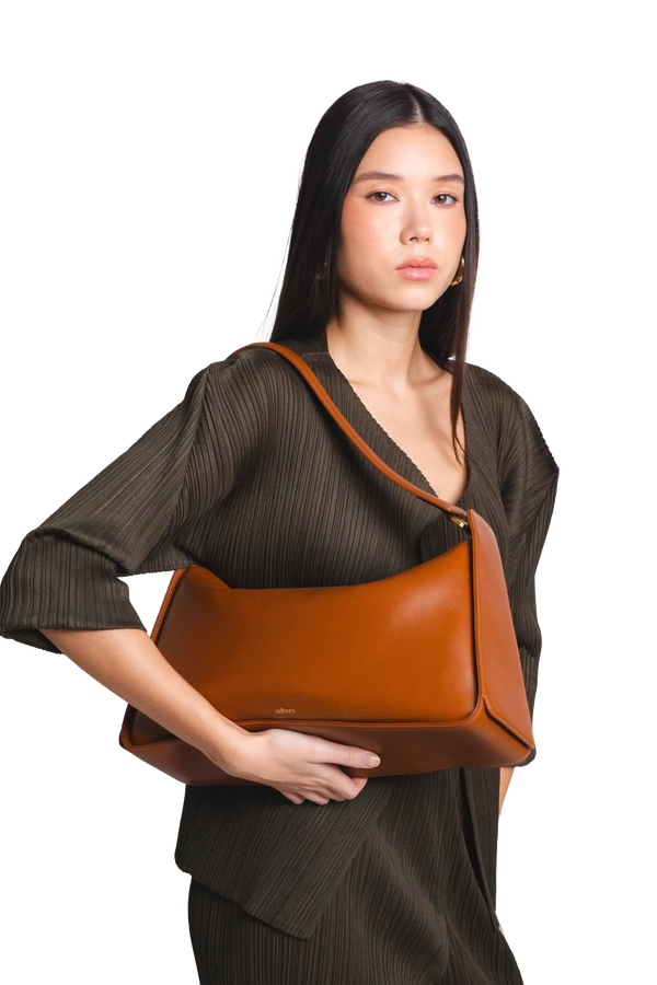 Bolsa de ombro em couro legítimo na cor marrom claro com fechamento por zíper e alça de ombro confortável, design sofisticado e funcional ideal para o dia a dia.