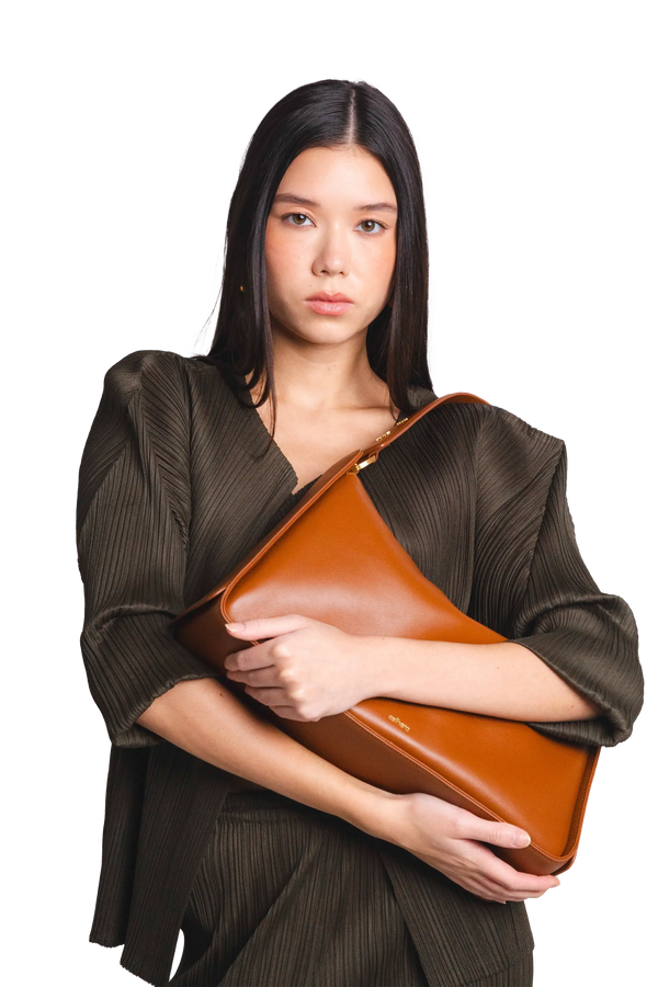 Bolsa de ombro em couro legítimo na cor marrom claro com fechamento por zíper e alça de ombro confortável, design sofisticado e funcional ideal para o dia a dia.