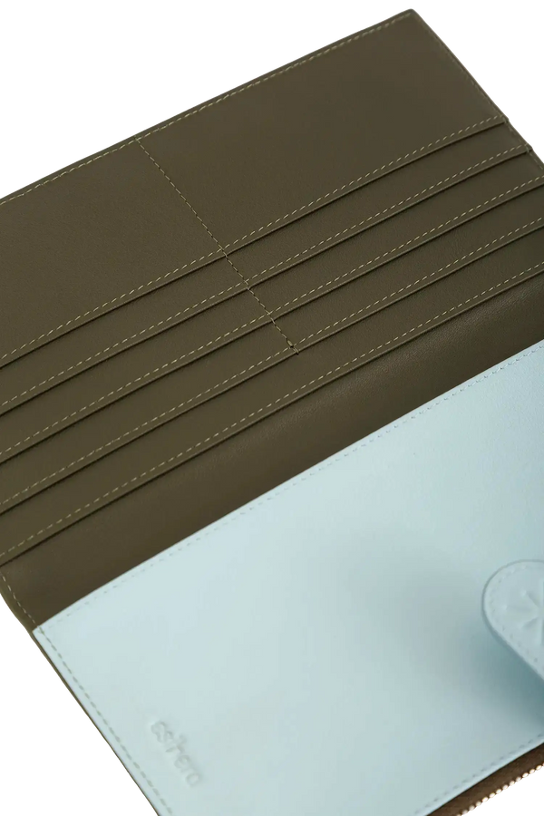 Porta-passaporte em couro legítimo na cor azul claro com divisórias exatas para passaporte, documentos de viagem e cartões de embarque, estética minimalista e moderna, ideal para otimizar o espaço na bolsa de forma prática e estilosa.