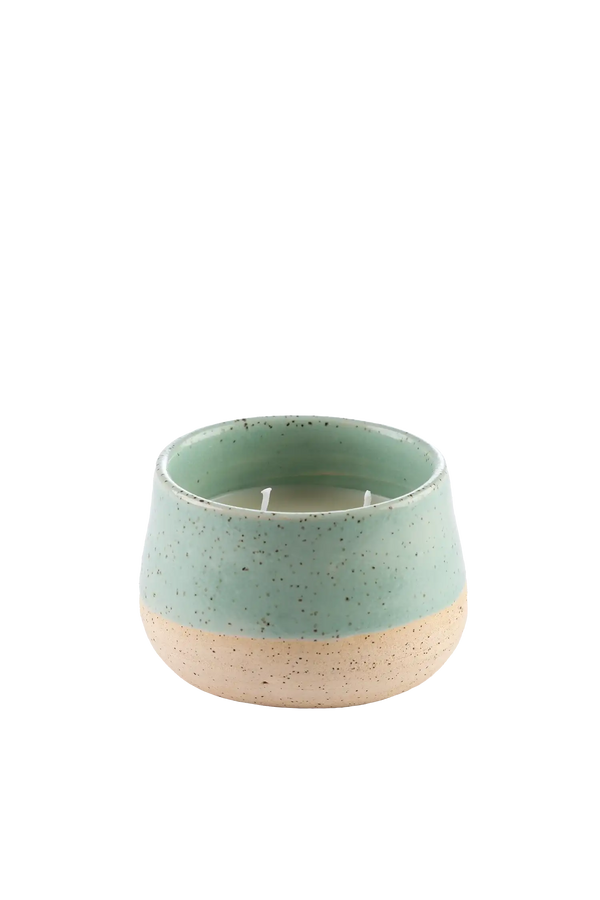 Vela aromática artesanal em recipiente de cerâmica artesanal com cera vegetal de coco na cor verde-mangaba com fragrância fresca de notas de limão siciliano, rosa, jasmim e vetiver, proporciona uma queima limpa e duradoura, exalando uma fragrância leve que renova as energias do lar.