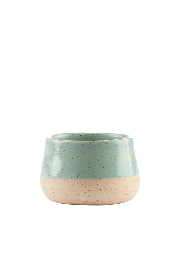 Vela aromática artesanal em recipiente de cerâmica artesanal com cera vegetal de coco na cor verde-mangaba com fragrância fresca de notas de limão siciliano, rosa, jasmim e vetiver, uma escolha sofisticada para presentear ou compor a decoração de salas e quartos com elegância e suavidade.